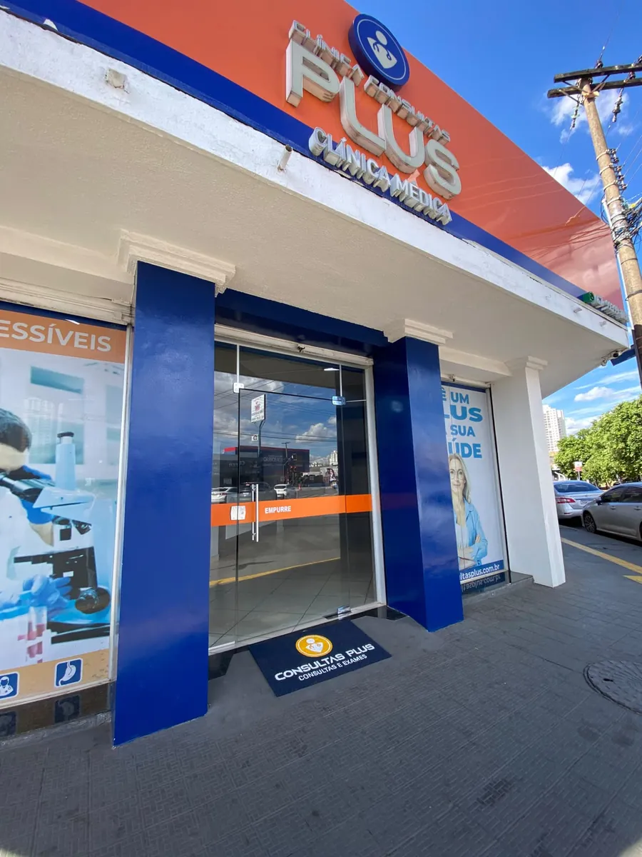 Entrada da clínica, com o letreiro laranja sobre a porta de vidro