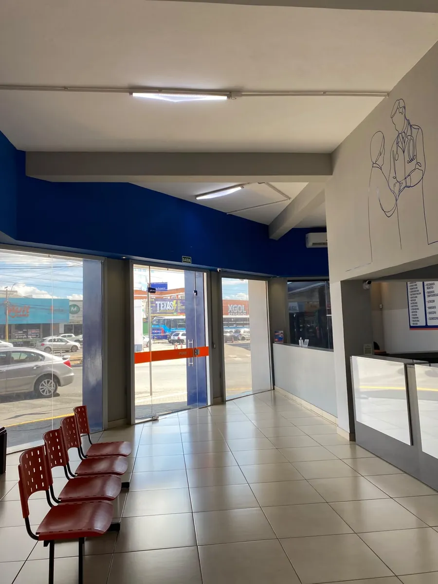 Recepção com o balcão de atendimento e a fachada de vidro